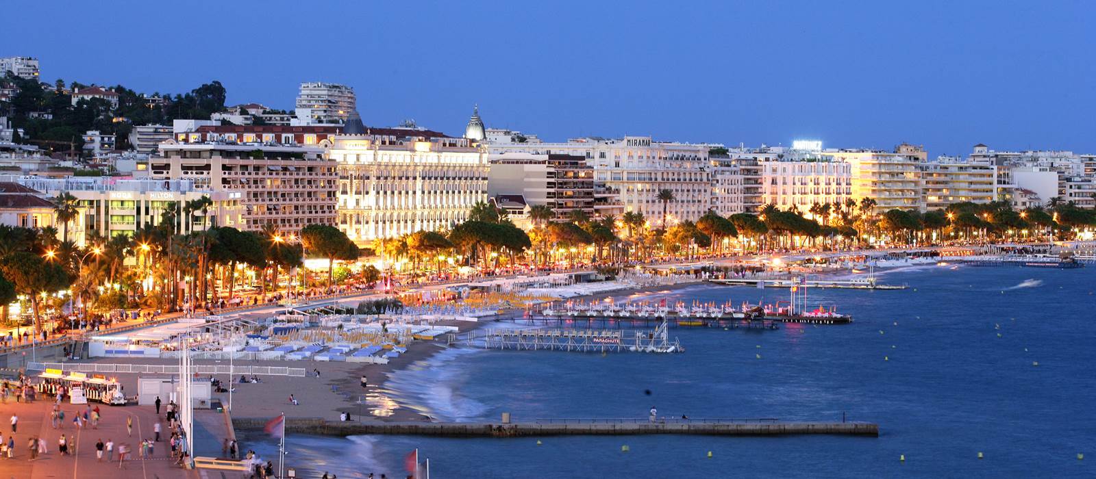 La Croisette de Cannes illuminée la nuit avec le Palais des Festivals en arrière-plan — ambiance prestige VTC